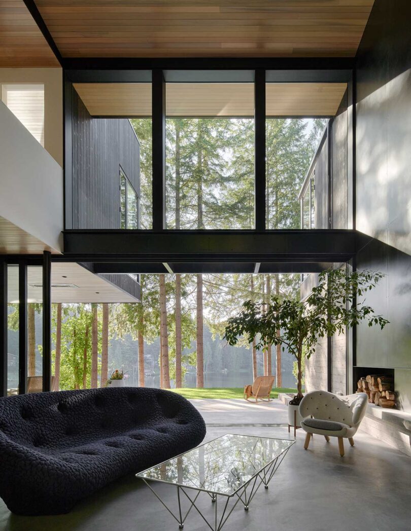 interior shot of modern living room with double height ceiling and wall of windows and modern furnishings