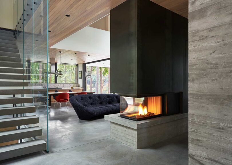 angled interior view of modern home with view into living room and end of fireplace