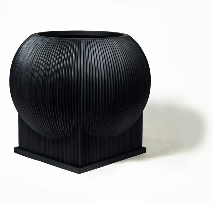 modern black fluted urn on white background