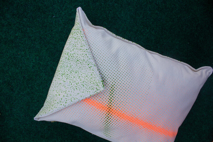 white pillow with neon orange stripe and green patterned envelope flap