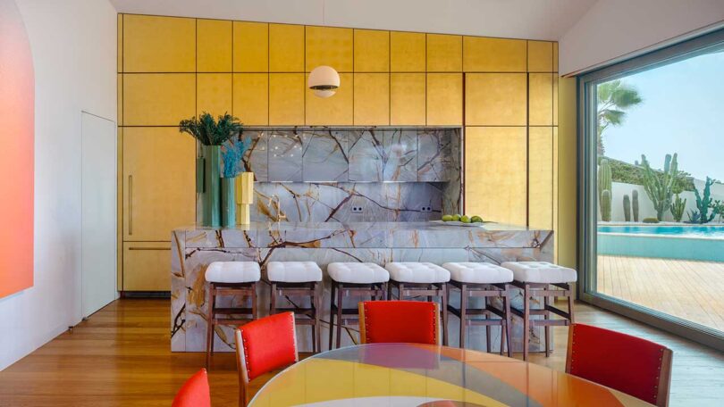 عکس داخلی آشپزخانه مدرن با کابینت های طلایی و پشتی سنگ مرمر