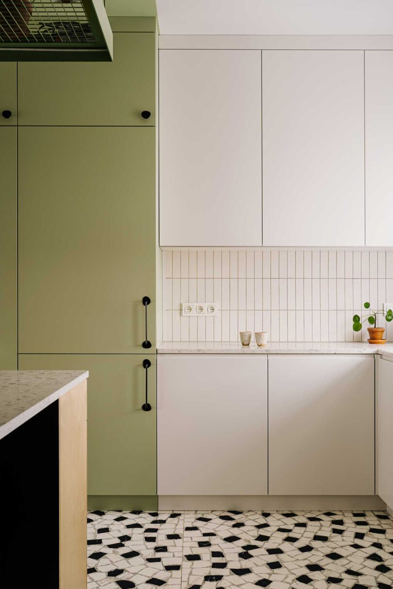 partial interior view of modern kitchen with mix of minimalist cabinets in white and sage green