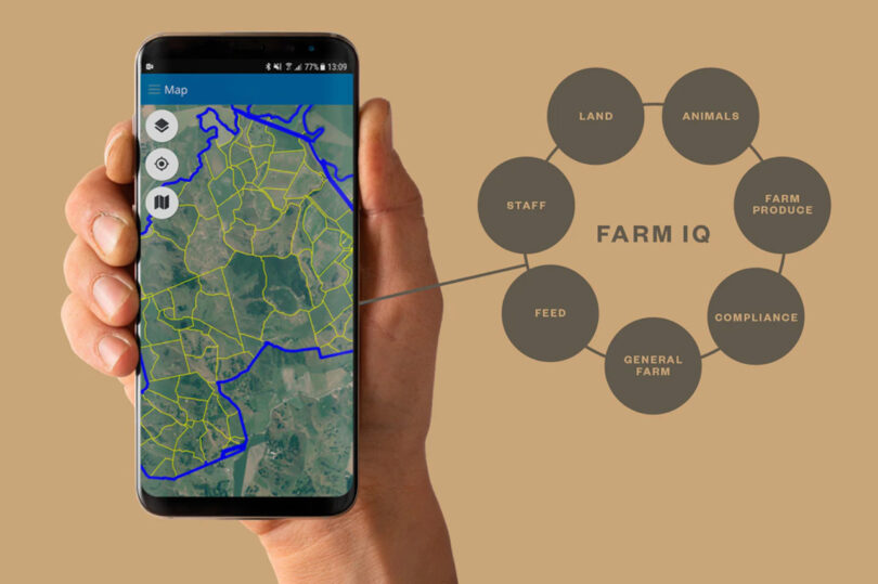 Hand holding up smartphone with map showing farmland borders.