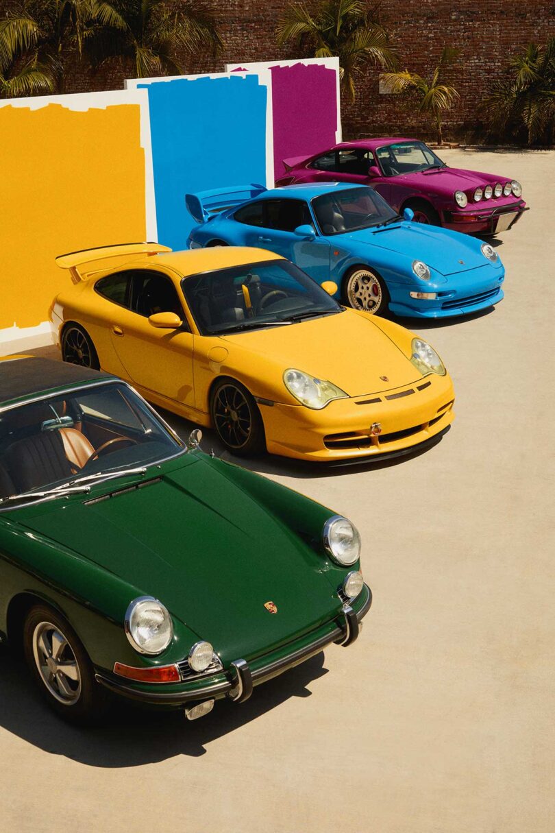 four angled in a row vintage Porsche cars in vibrant colors matching large paint swatches behind them