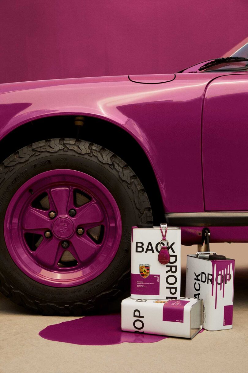 closeup partial view of vintage Porsche painted in magenta Backdrop paint with open cans in front