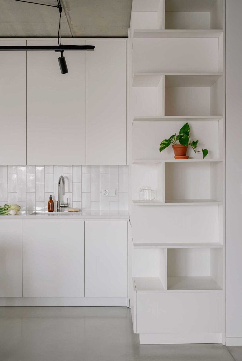 partial view of modern minimalist white kitchen in apartment
