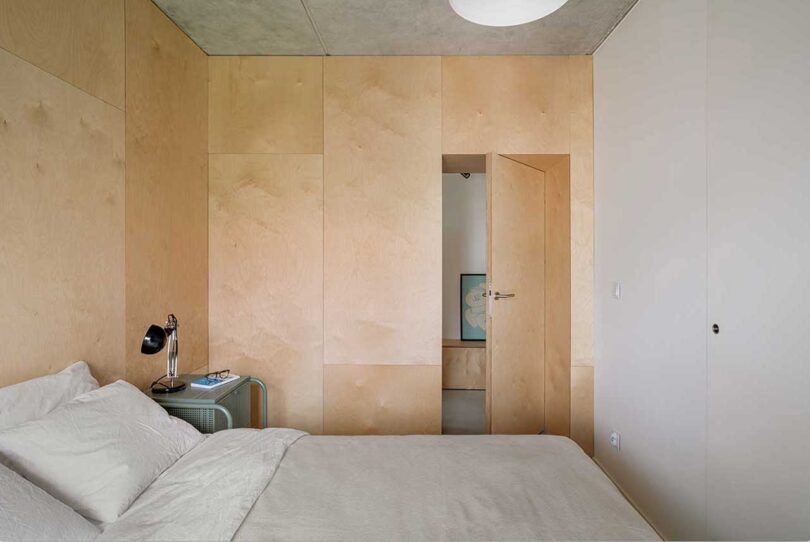 side view of modern minimalist bedroom with light wood walls