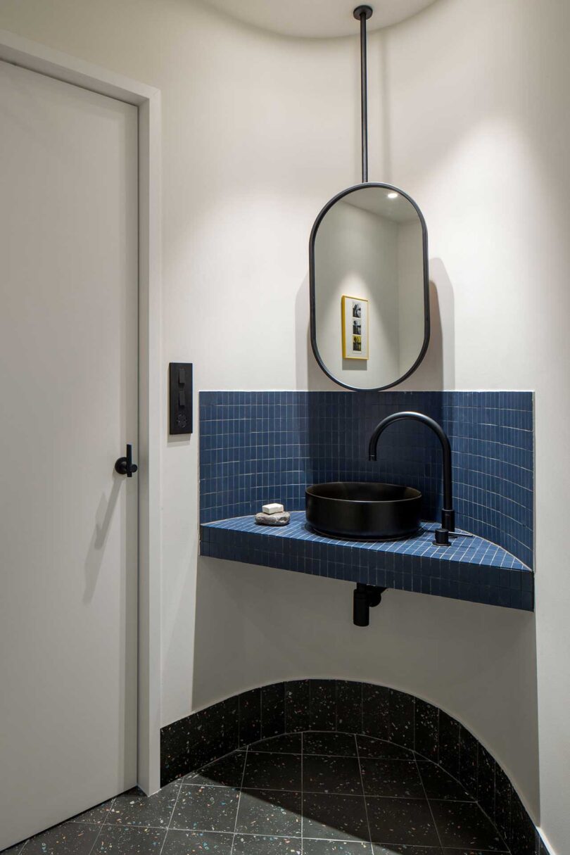 angled view of small bathroom with navy blue tiles
