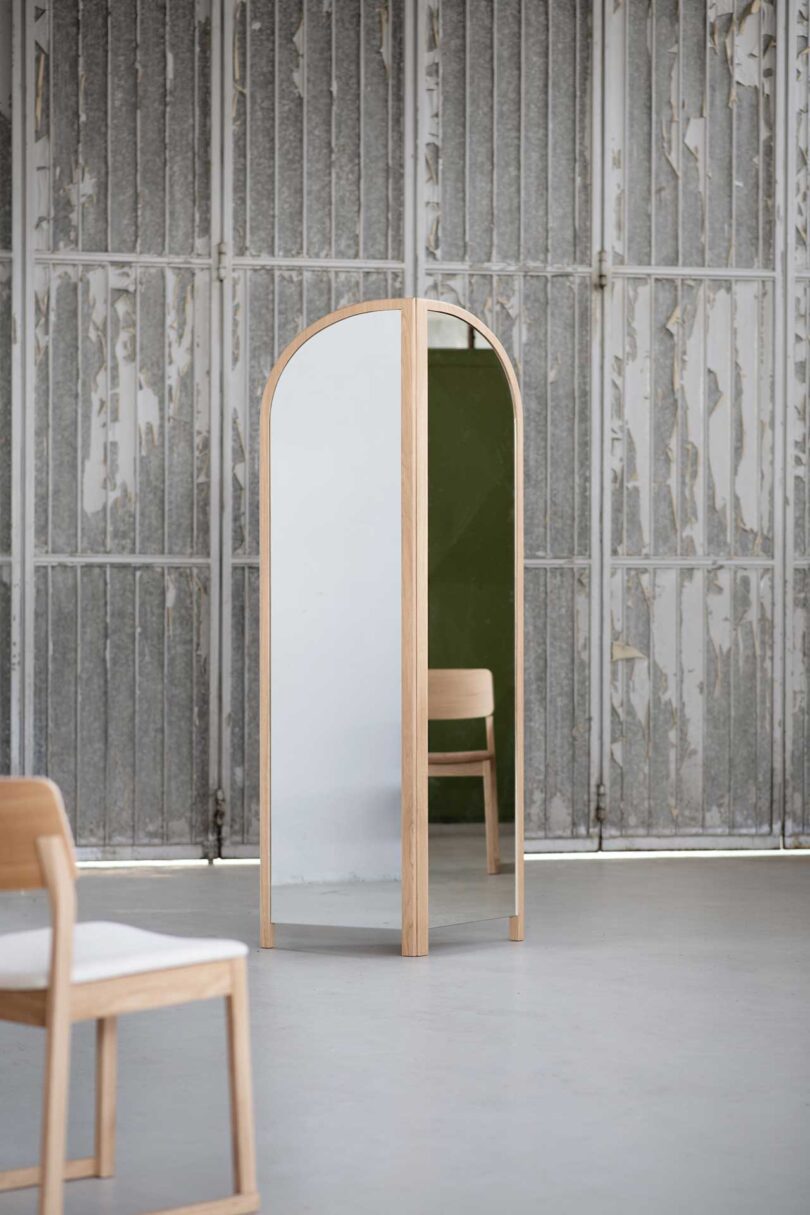 light wood arch-shaped bi-fold floor mirror in styled space