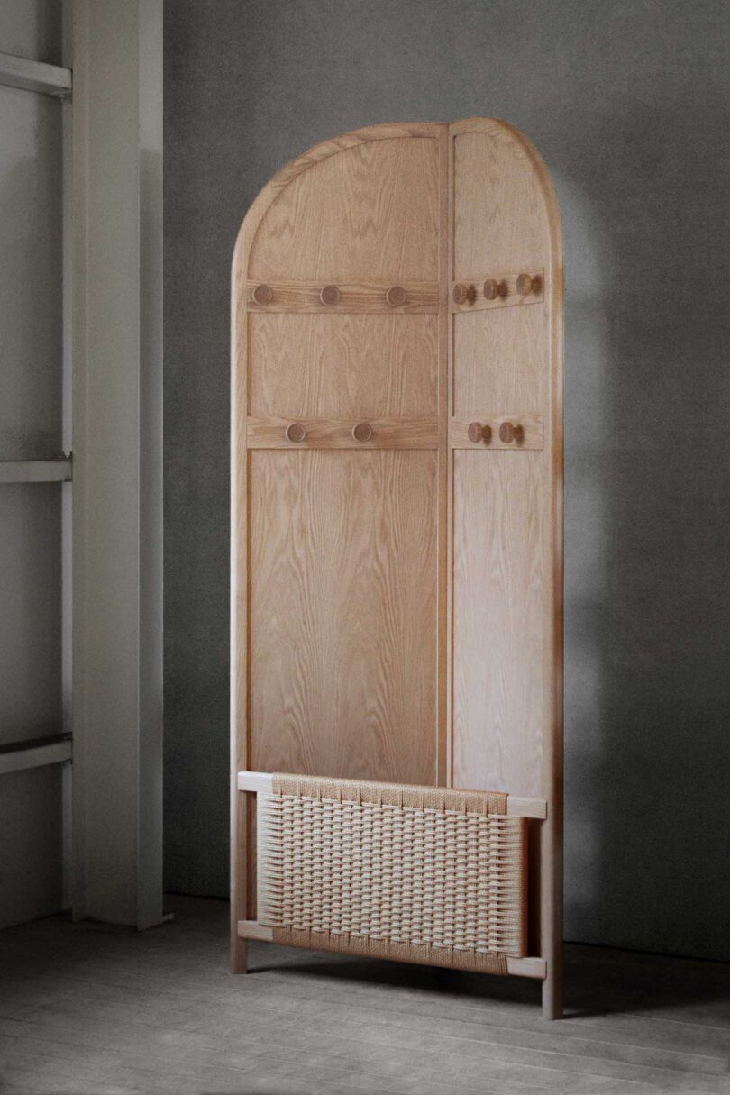 light wood arch-shaped bi-fold floor coat rack in styled space