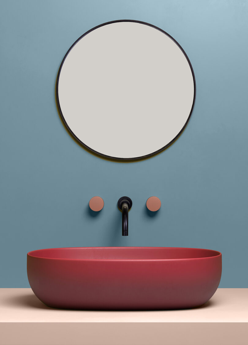 rounded maroon sink with mauve faucet handles