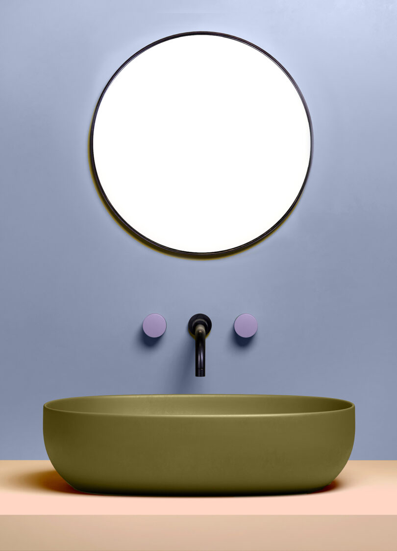 rounded olive green sink with lavender faucet handles
