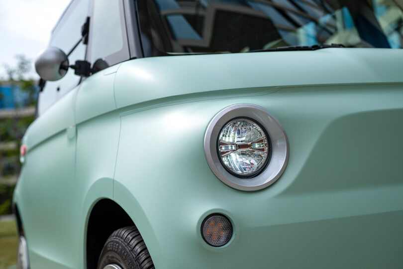 closeup partial view of mint-colored small EV Fiat