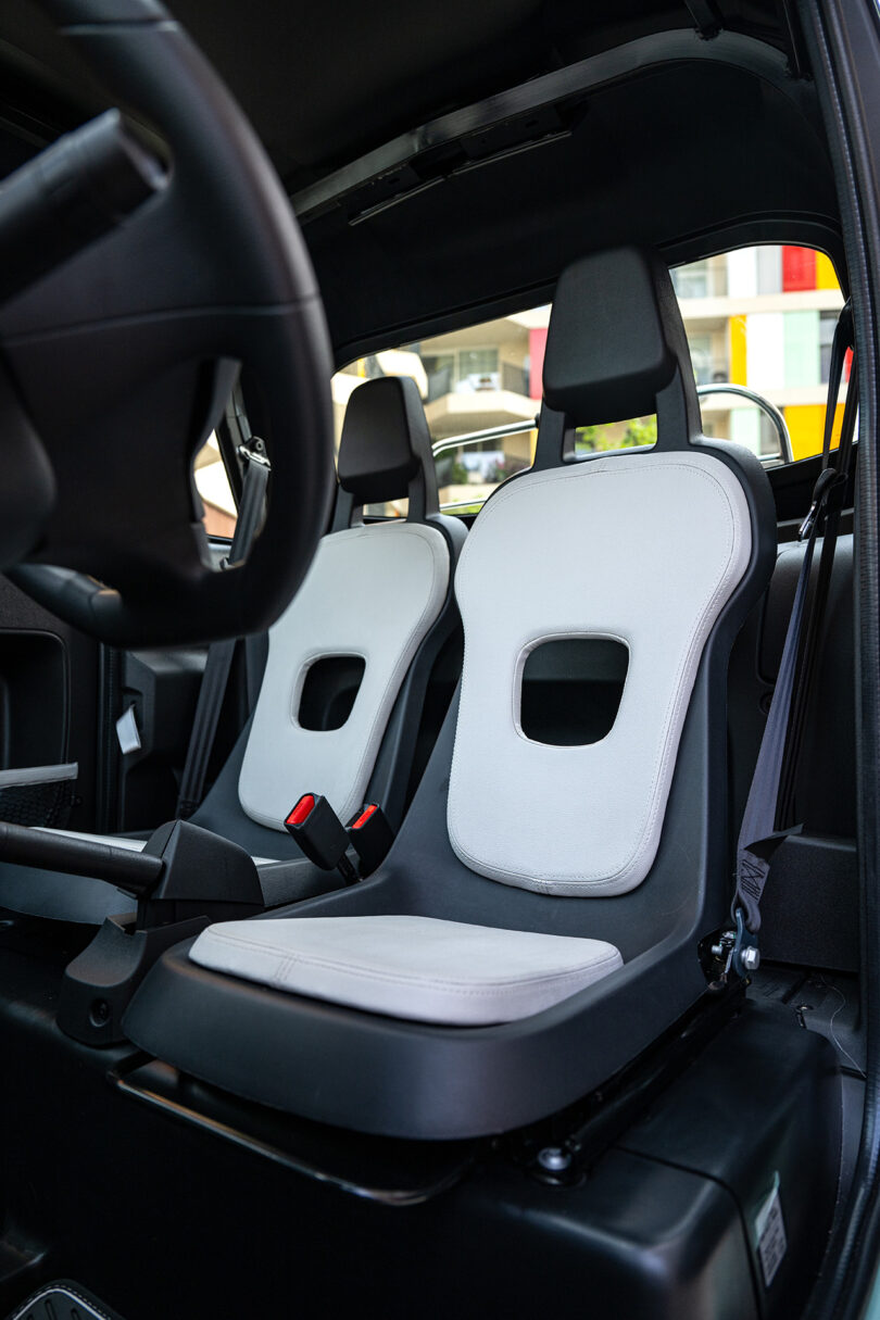 interior car view of two black bucket seats with light grey padding