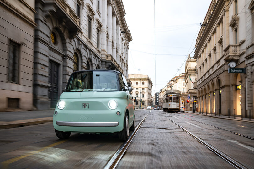 city street view of small mint-colored Fiat car