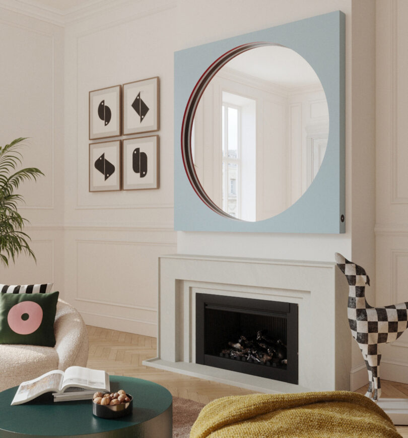 round mirror within large baby blue square frame in a styled space