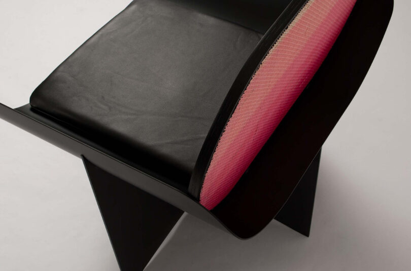 detail of modern black armchair with pink gradient backrest