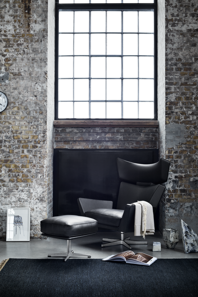 interior space with brick walls and a black armchair with matching ottoman