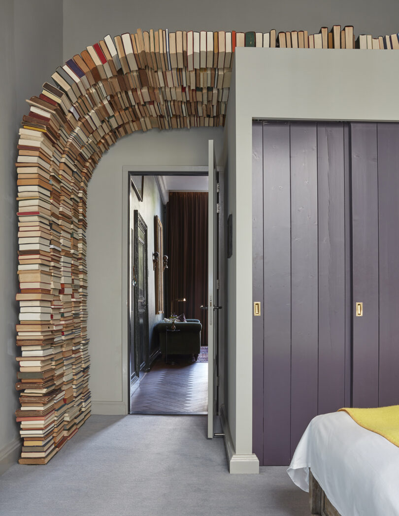 interior space with an arched doorway made out of stacked books