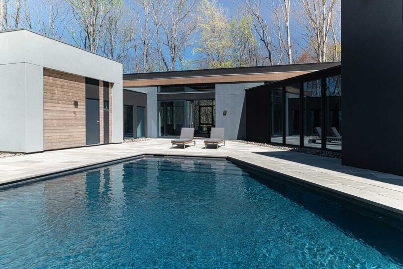 exterior view of modern house wrapped around a large pool