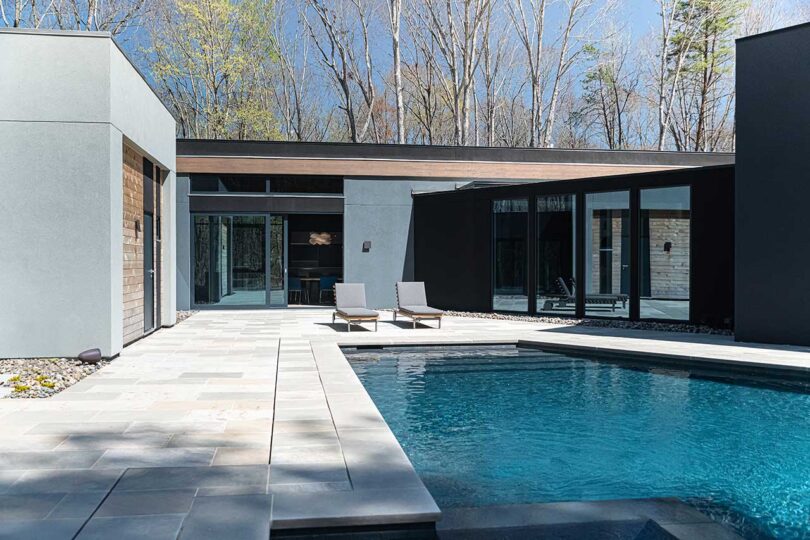 exterior view of modern house wrapped around a large pool