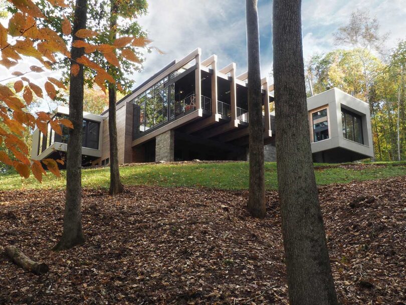 view up hill looking at modern home exterior with cantilevered rooms