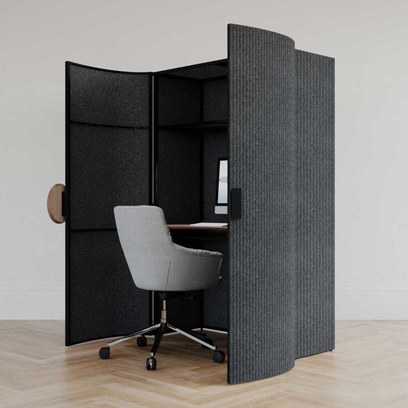 angled view of black rounded front cabinet with doors slightly open revealing a desk chair
