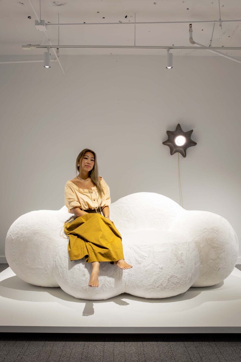 woman perched atop a cloud-shaped daybed