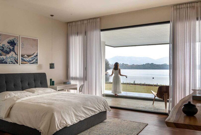 angled view of modern bedroom with open veranda with views of lake