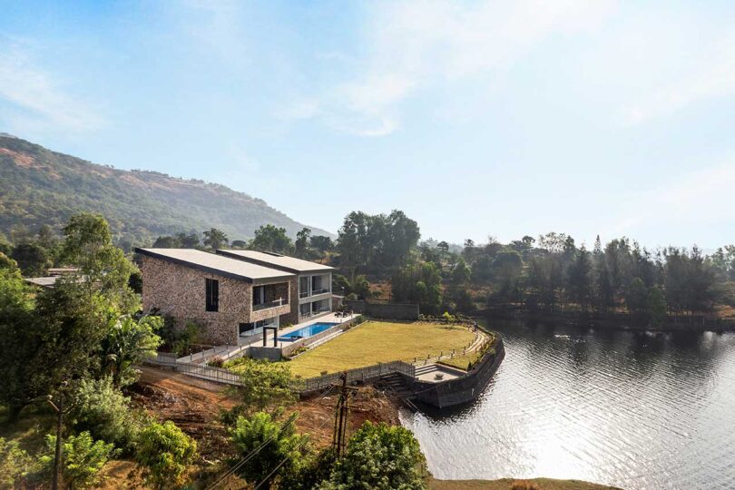 angled aerial view of large modern house on lakefront