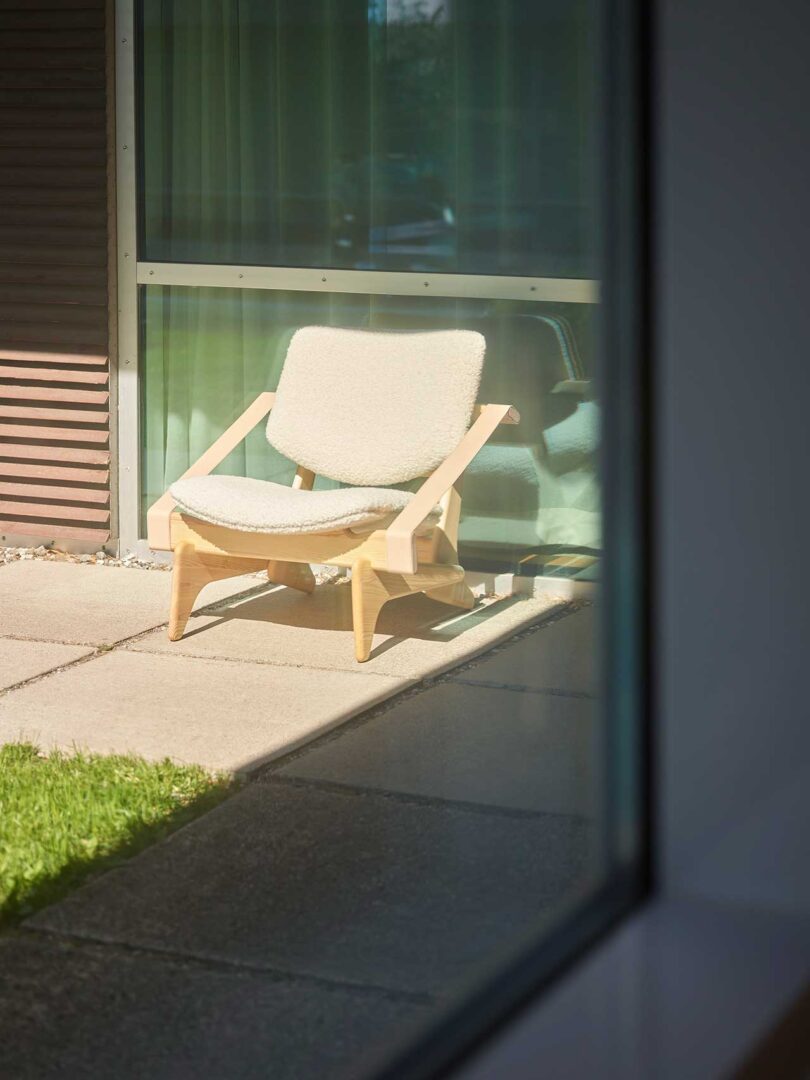 cadeira baixa de madeira com assento e encosto estofados ao ar livre