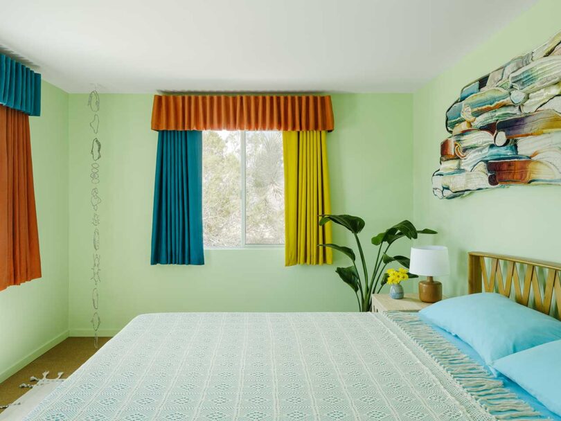 modern bedroom with pale green walls and multicolored curtains