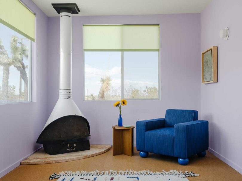 interior shot of modern living space with upholstered blue chair and white corner stove