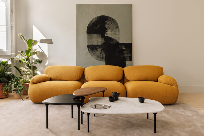 styled interior space with goldenrod modular sofa and nesting tables