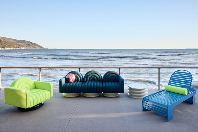 neon green channel tufted armchair, blue channel tufted sofa, and blue chaise lounge on a deck overlooking the ocean