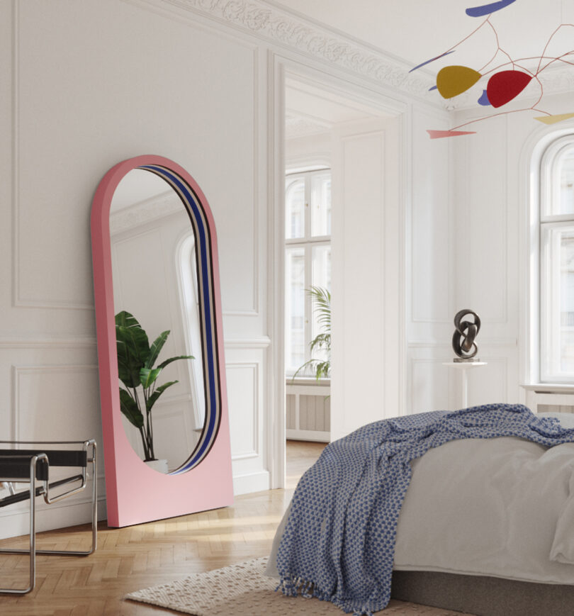 large floor mirror within a light pink frame in a styled space