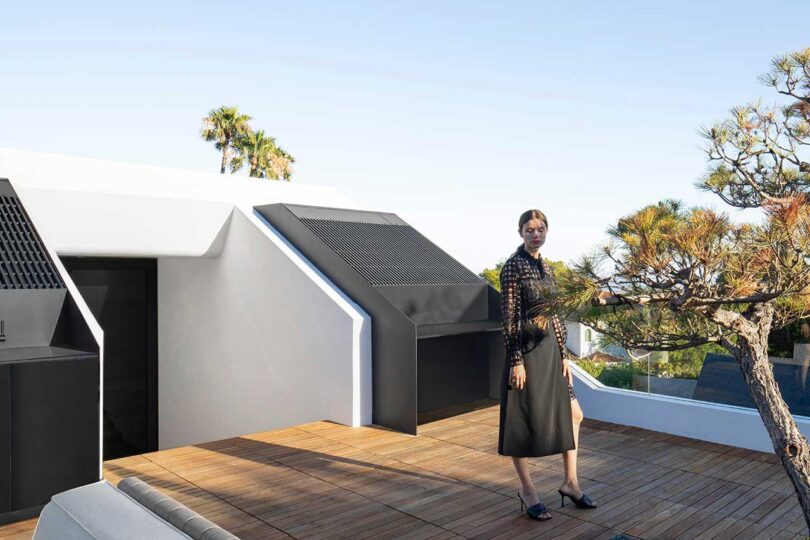 exterior view of woman standing on a roof deck of modern home