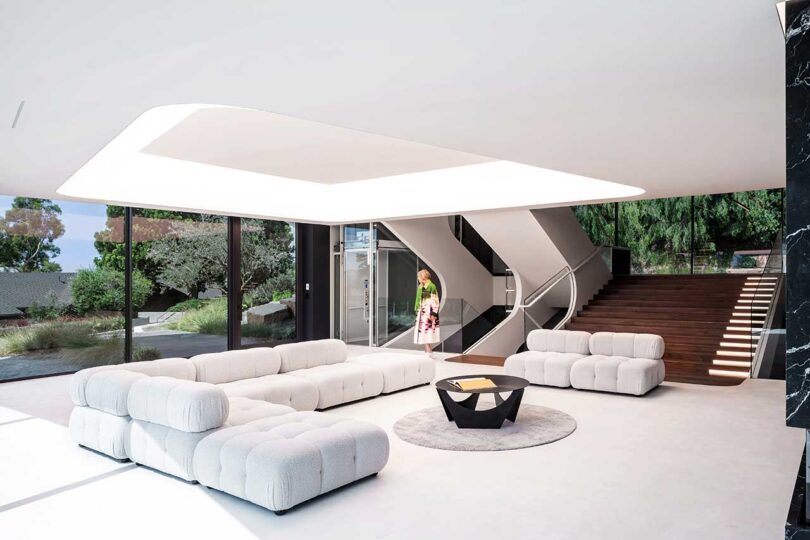 angled interior view of modern futuristic living room with large white modular sofa