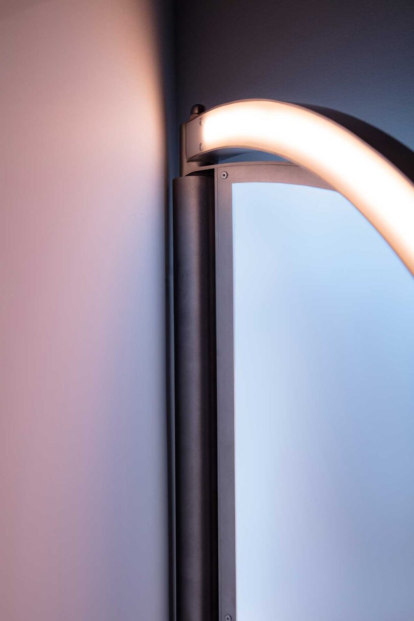 detail of an oval-shaped wall light that resembles a window when illuminated