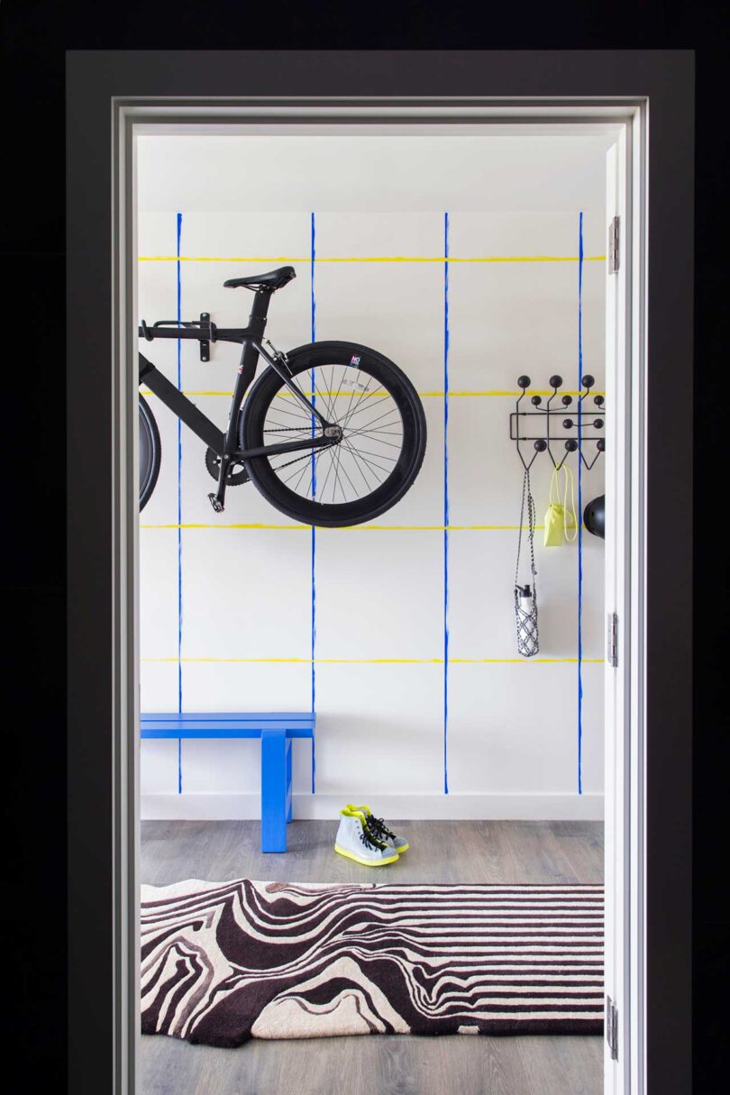 apartment hallway with blue bench and bike hanging