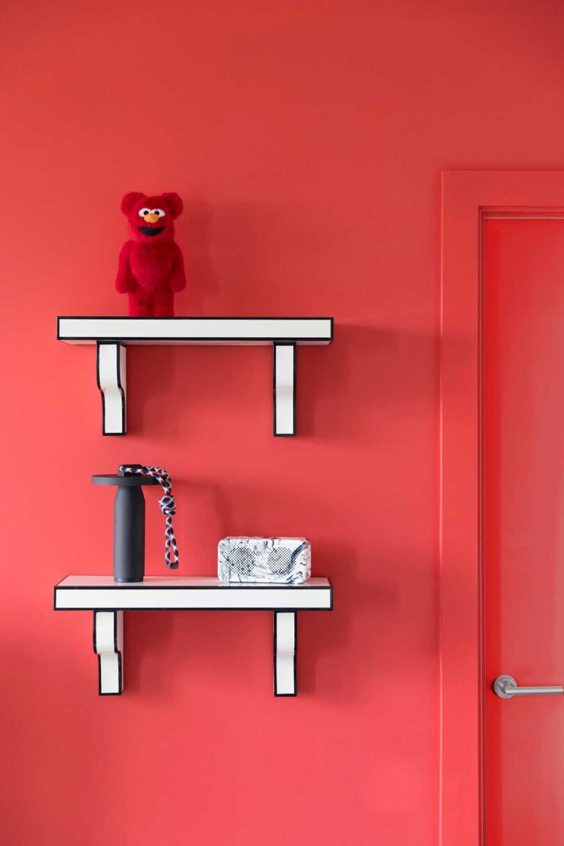 closeup view of red interior wall with black and white cartoonish shelves