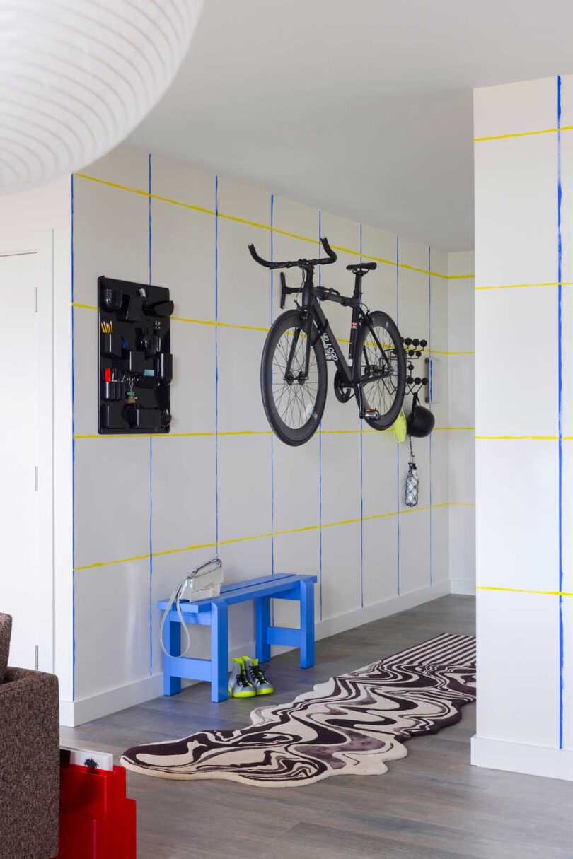 angled interior view down apartment hallway with blue bench and bike hanging