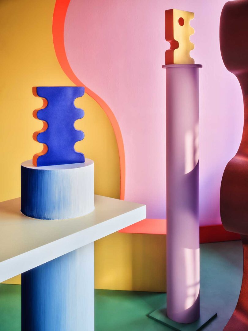 interior view of colorful quirky space with column and table holding abstract vases.