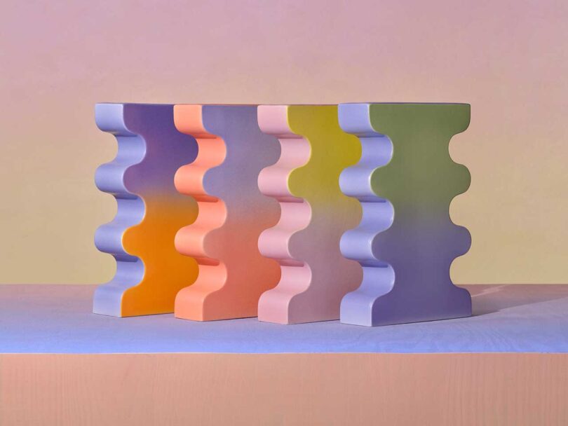 angled set of curvy geometric colorful vases in a row