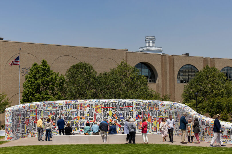 large colorful curved mosaic wall art installation being observed by people