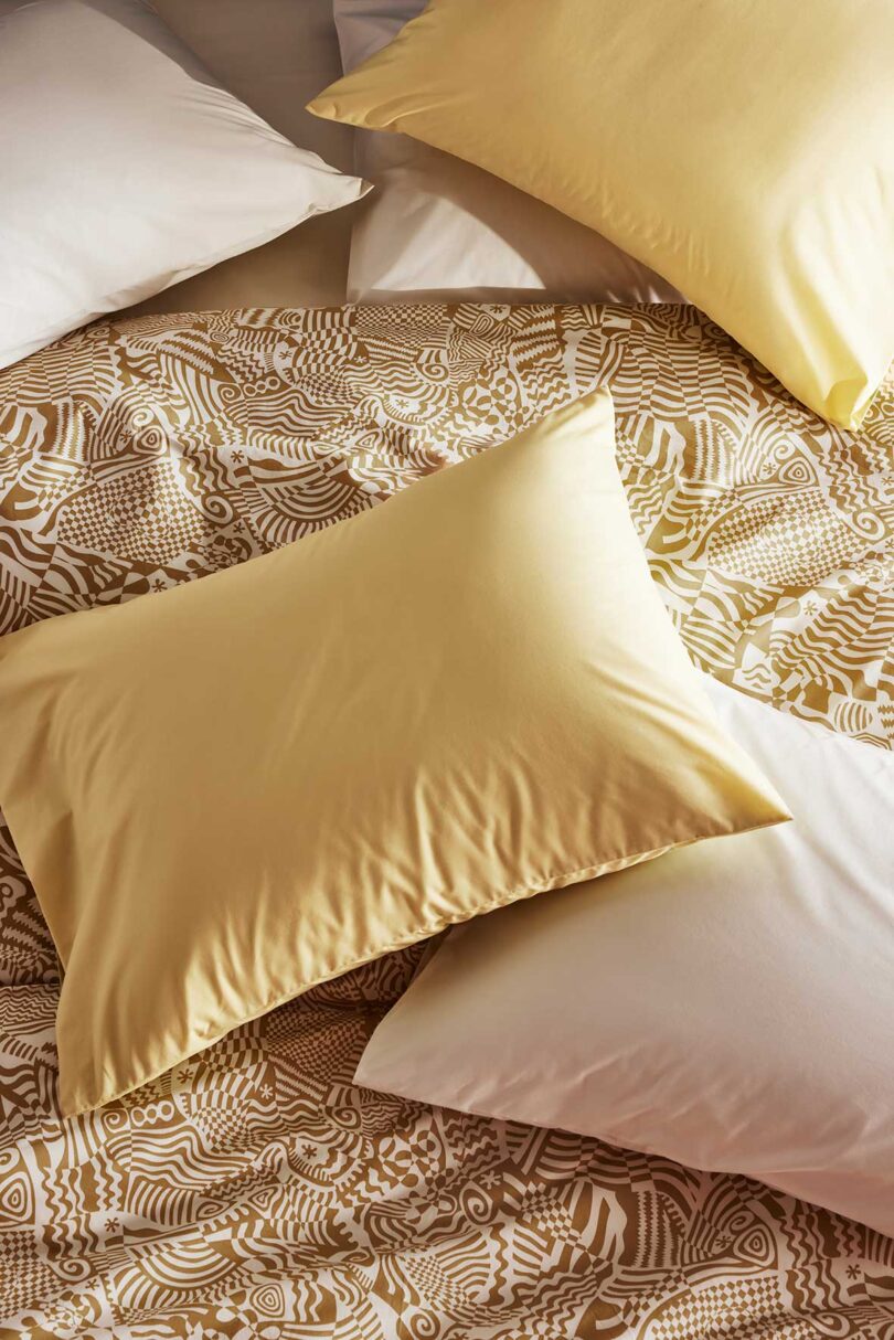 cropped down view of golden yellow and white patterned bedding