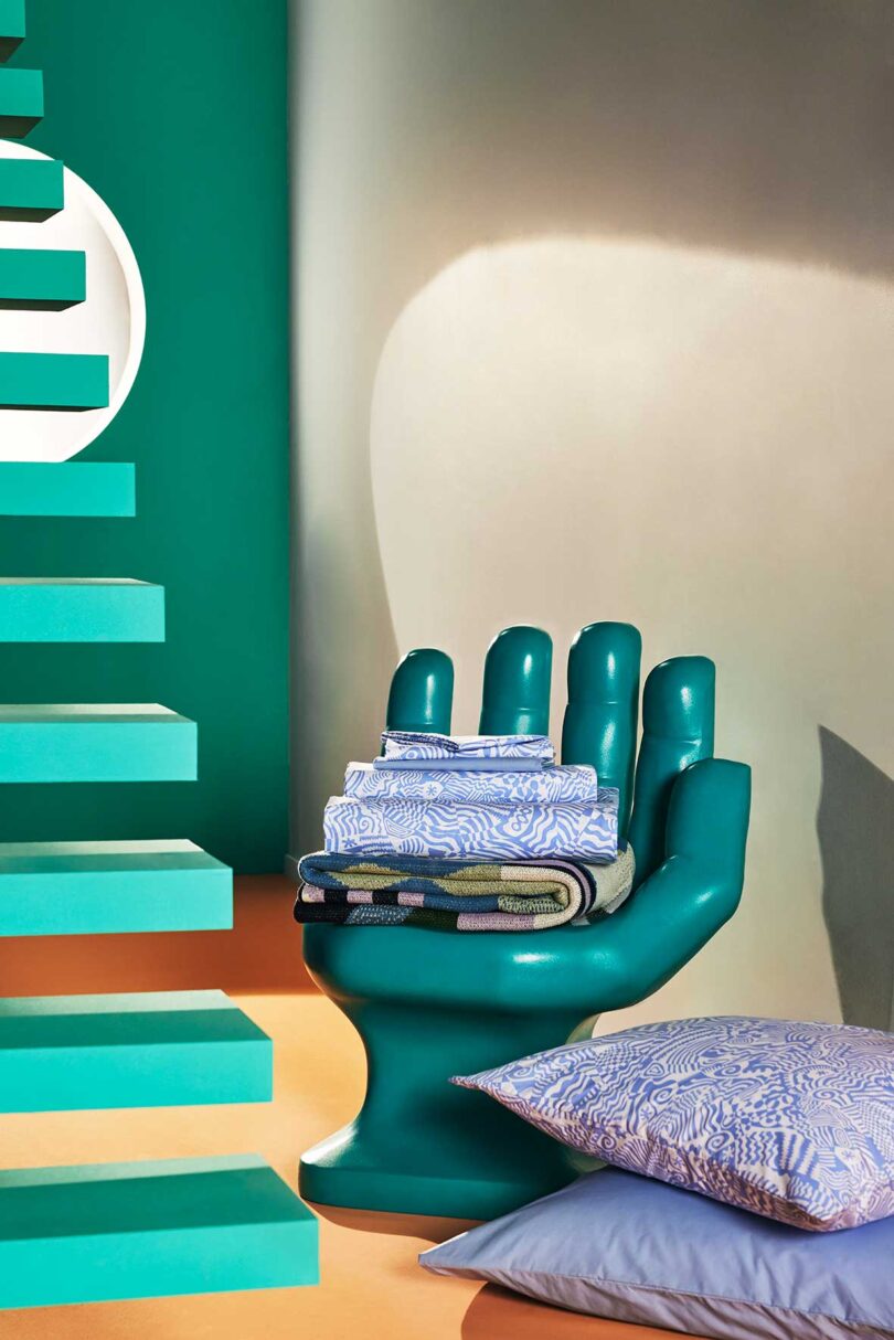 cropped interior view of floating green stairs with green hand chair holding patterned bedding