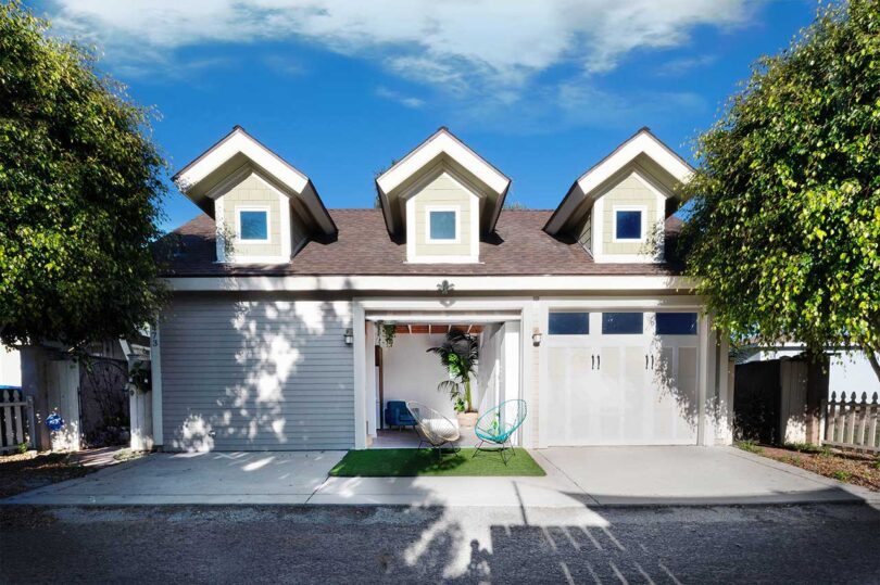 exterior view of renovated garage with center door open revealing flex space