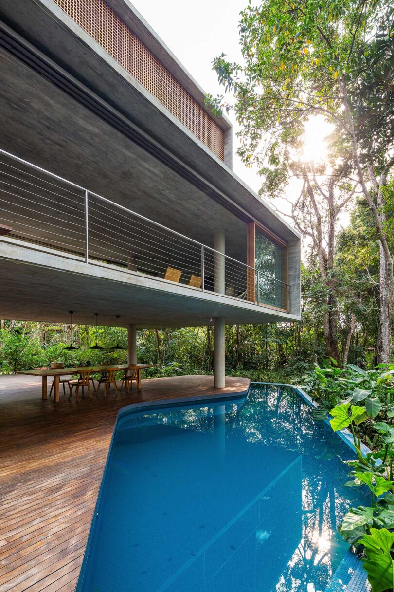 vista externa angular de uma casa moderna elevada com deck coberto e piscina