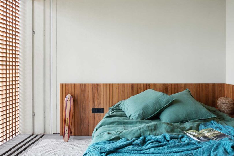 vista parcial del dormitorio moderno con ropa de cama verde azulado